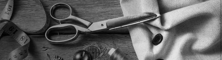 Tailoring tools: scissors, a tape measure and buttons